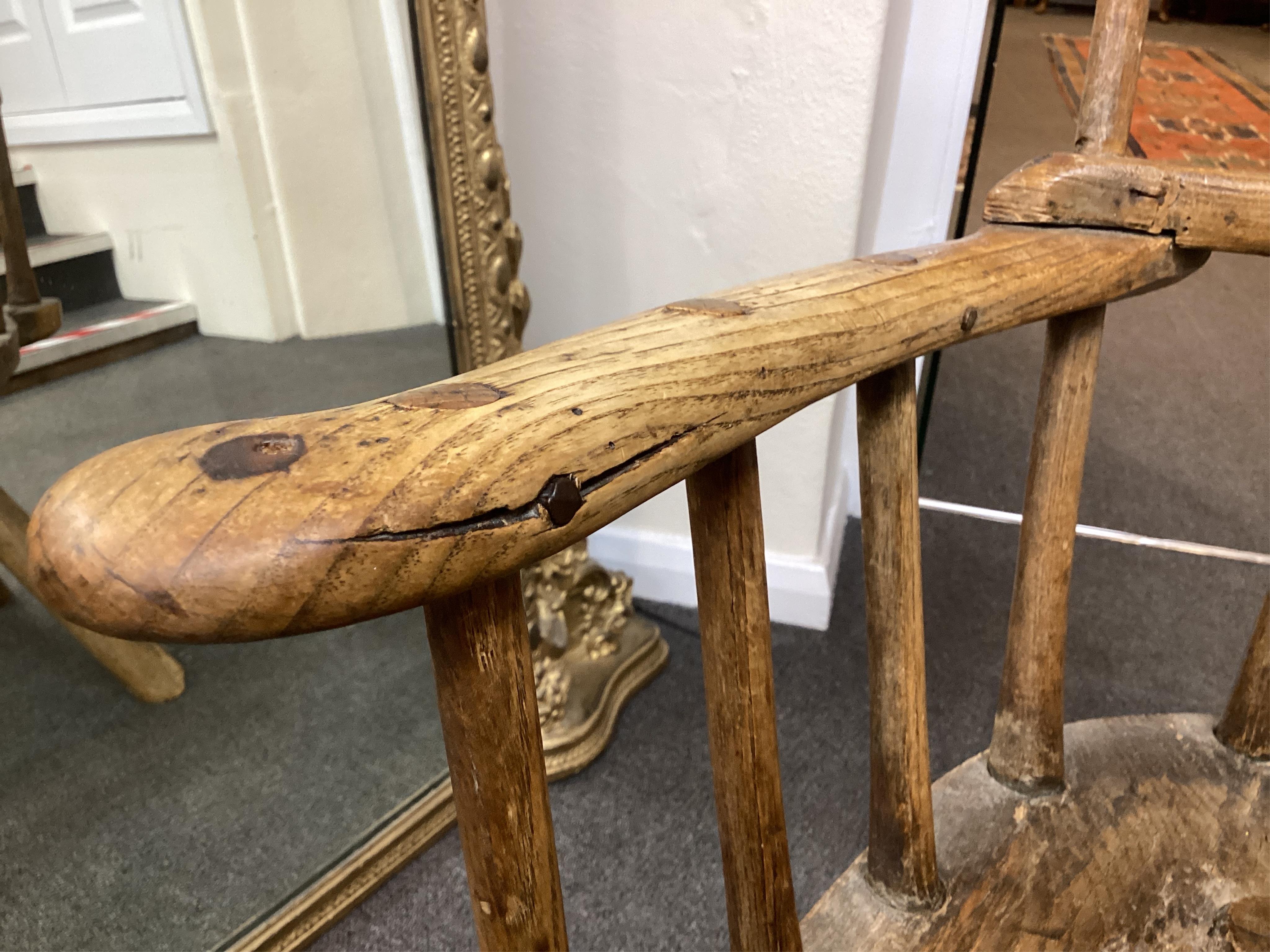 An 18th or 19th century primitive ash and elm Windsor armchair